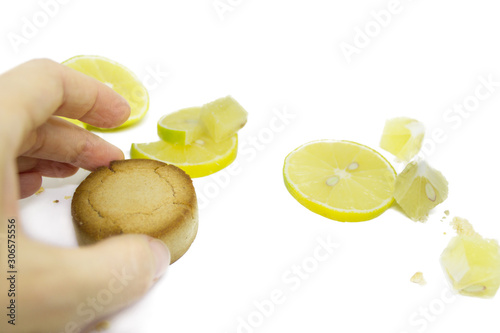 Female hand takes a cookie mantecado, polvoron on a white isolated background. Lemon cookies, lemon photo