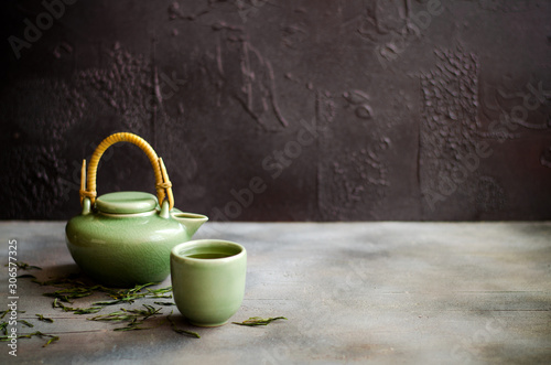 Chinese green tea in teapot on dark background
