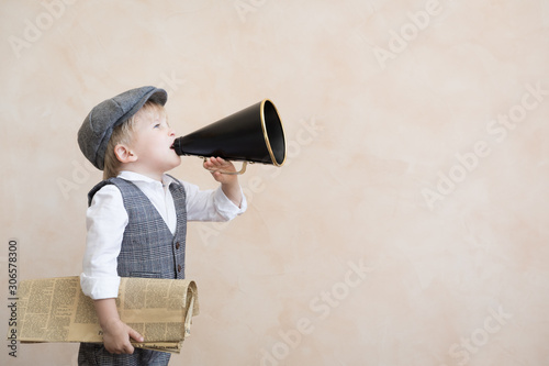 Child shouting through vintage megaphone photo