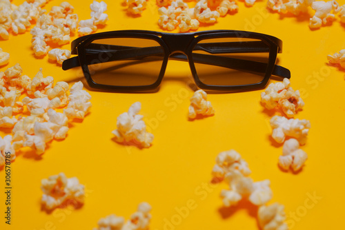 Cinema session, film, popcorn, 3D glasses. View movie concept, cinema, discounts. Yellow cinema background. Glasses for 3D movie in popcorn.