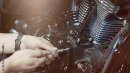 The mechanic is twisting bold in a motorcycle 