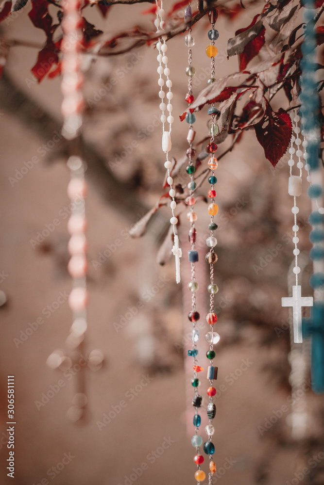 Tree with the handing crosses near church. Religion symbols. Santa Fe. New Mexico. USA