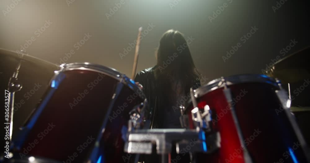 A professional drummer is playing rock music with band. Experienced musician is beginning the performance in club - music concept 4k footage