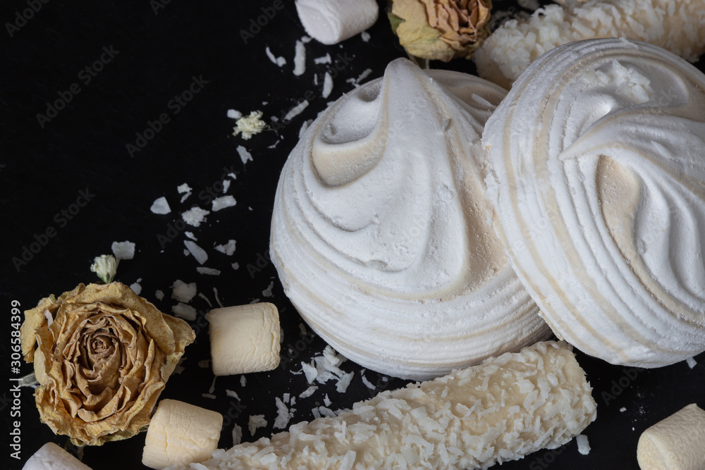 airy white marshmallows on a black background top and side view. Delicious dessert, mashmeloe, coconut and pepper sticks. Cooking and sweets recipe airy white marshmallows on a black background top and side view. Delicious dessert, mashmeloe, coconut and pepper sticks. Cooking and sweets recipe