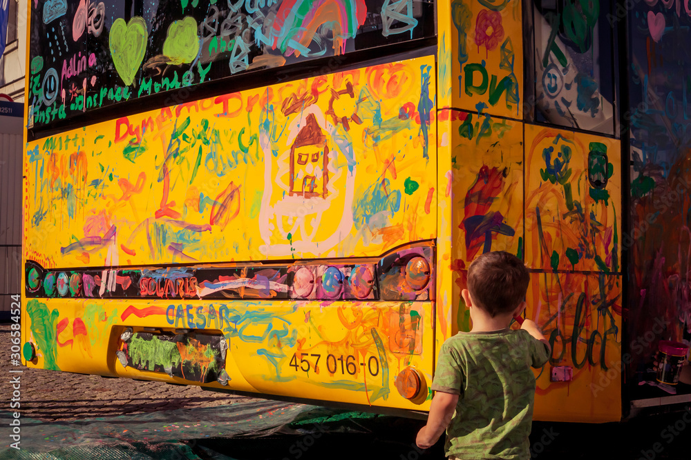 Fototapeta premium Ein Kind malt einen Bus an