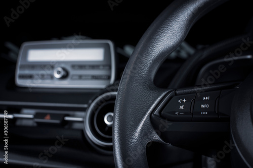 Multimedia button on multifunction steering wheel in a luxury car. © BLKstudio