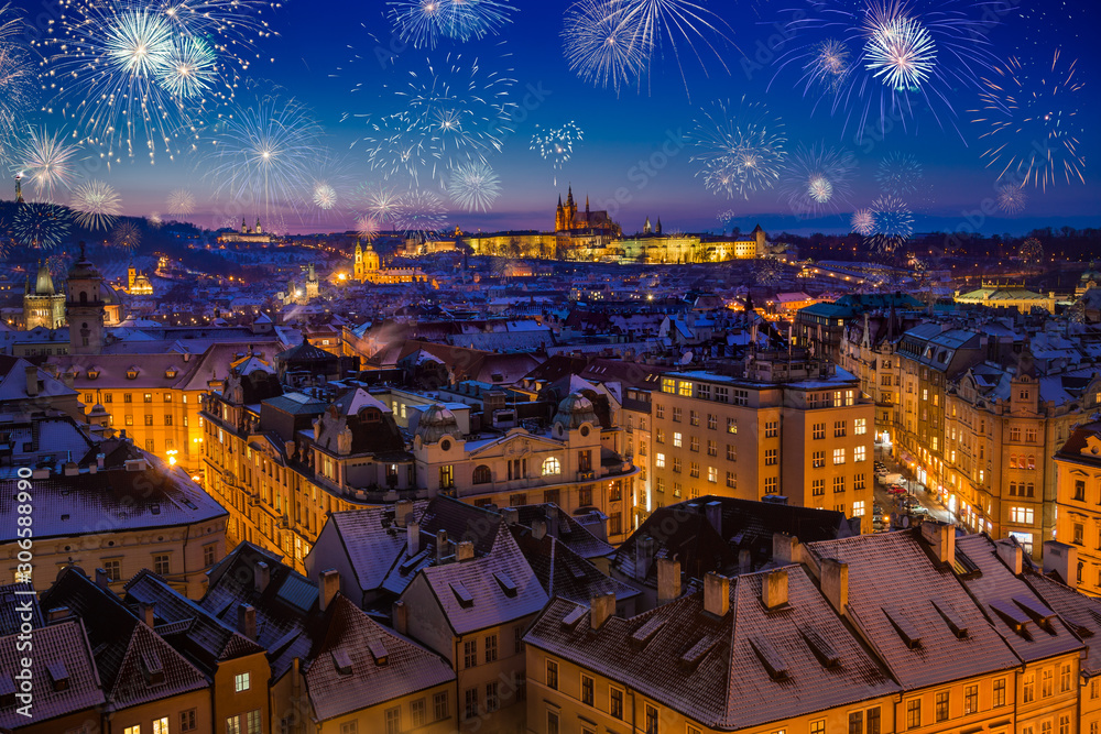 Obraz premium Prague Castle with snowy rooftops during late christmas sunset with blue sky and glowing street lights