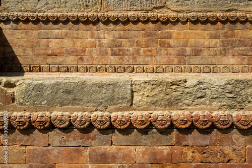 Graceful ancient stone carving. Brown stone texture. Wall of an old Hindu temple at Durbar Square in Kathmandu, Nepal