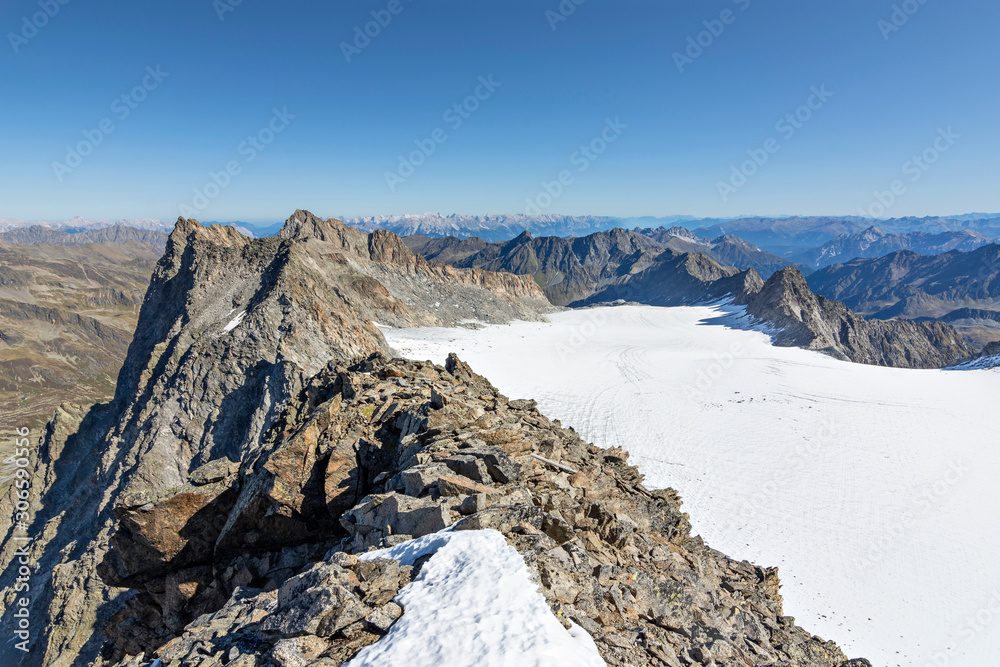 Wild alpine landscape with snow, glaciers and rocky mountains under blue sky in the Stubai Alps (Tirol, Austria).