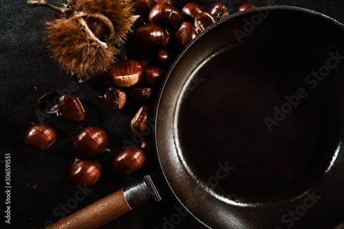 Maronen mit der Esskastanien Frucht und einer grusseisernen Pfanne
