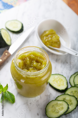 A delicious healthy breakfast with homemade cucumber jam and its ingredients in a glass jar