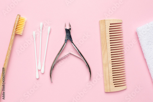 Eco wooden toothbrush   comb and nippers on pink background   bathroom and spa accessory