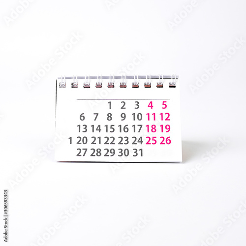 Pure white desktop calendar on a white table with copy space