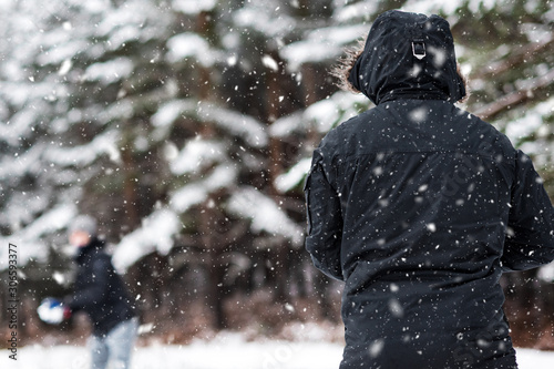 Young Happy friends enjoying throwing Snow balls, Having Fun in a Snowy Mountain .