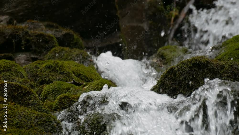 Green moss stones in the Carpathian mountains. Wonderful mountain waterfall cascade falls near large grey rocks Green moss stones in the Carpathian mountains. Wonderful mountain waterfall cascade falls near large grey rocks