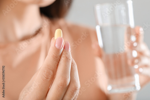 Young woman taking pill  closeup