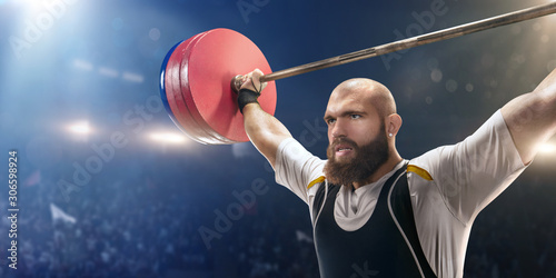 Male athlete is lifting a barbell on a professional stadium. Stadium and crowd are made in 3d.