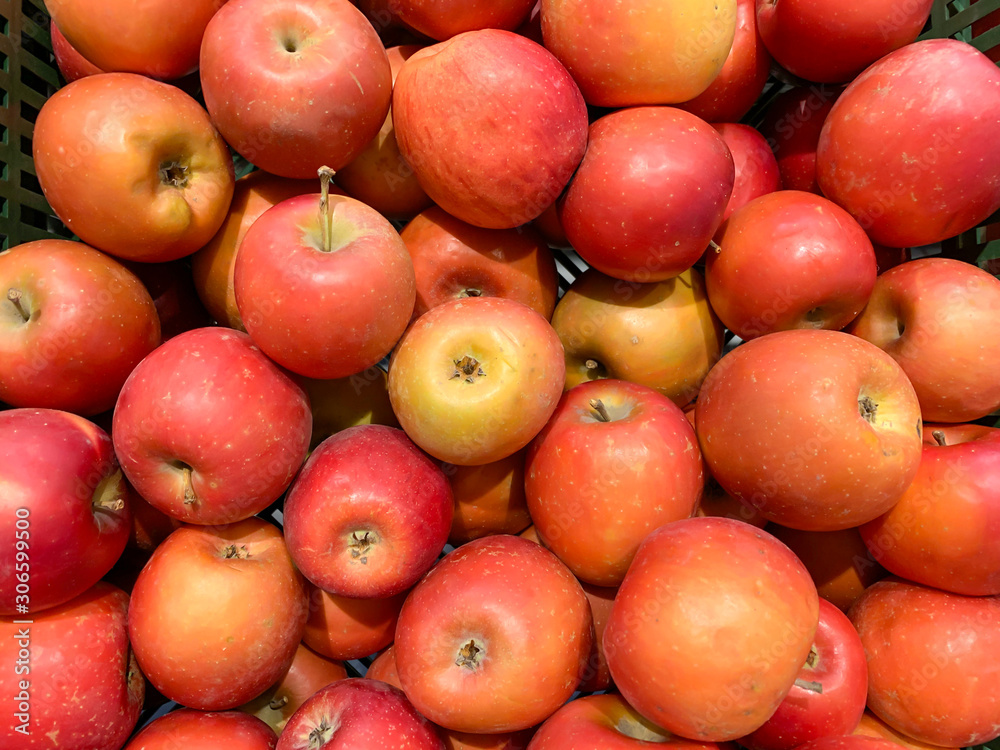 Many beautiful fresh juicy red apples in a box in a supermarket as a background Many beautiful fresh juicy red apples in a box in a supermarket as a background