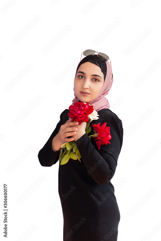 Stylish Muslim woman in traditional Islamic clothing holding flower bouquet. Portrait of beautiful middle-eastern girl in Hijab. Stock photo of Islamic clothing, fashion Stylish Muslim woman in traditional Islamic clothing holding flower bouquet. Portrait of beautiful middle-eastern girl in Hijab. Stock photo of Islamic clothing, fashion
