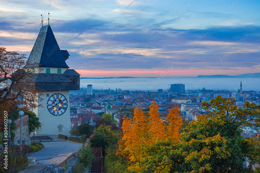 Cityscape of Graz and the famous clock tower (Grazer Uhrturm) on Shlossberg hill, Graz, Styria region, Austria, in autumn, at sunrise Cityscape of Graz and the famous clock tower (Grazer Uhrturm) on Shlossberg hill, Graz, Styria region, Austria, in autumn, at sunrise
