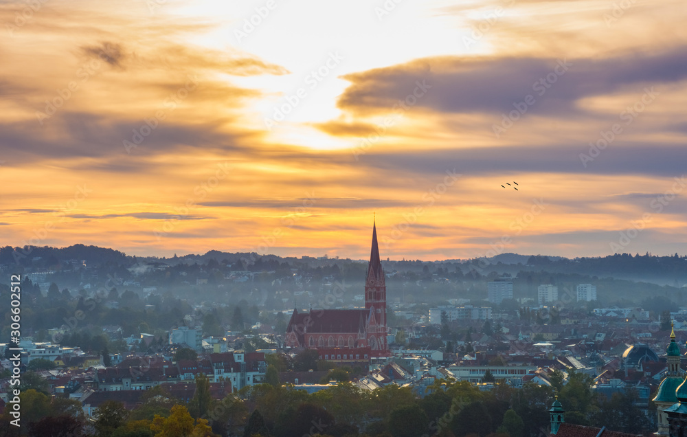 Cityscape of Graz with Church of the Sacred Heart of Jesus (Herz Jesu Kirche) and historic buildings, in Graz, Styria region, Austria, at sunrise.