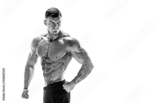 Tattooed muscular super-high level handsome man posing in studio isolated on white background