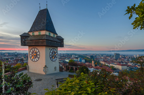 Cityscape of Graz and the famous clock tower (Grazer Uhrturm) on Shlossberg hill, Graz, Styria region, Austria, in autumn, at sunrise photo