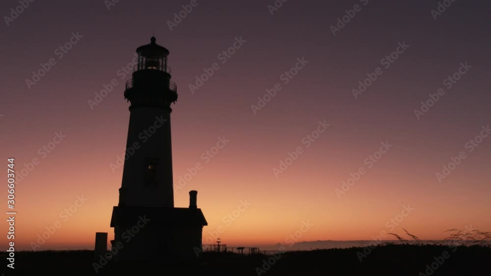 Silhouette of the Yaquina Head Lighthouse against the purple sky at dusk just after sunset Silhouette of the Yaquina Head Lighthouse against the purple sky at dusk just after sunset