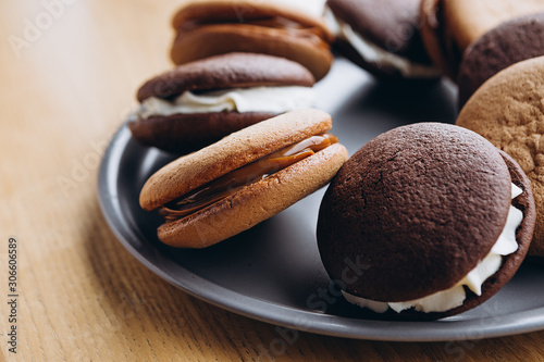 Close up Traditional chocolate and Pumpkin Whoopie pies filled made with vanilla cream cheese in cozy cafe background photo