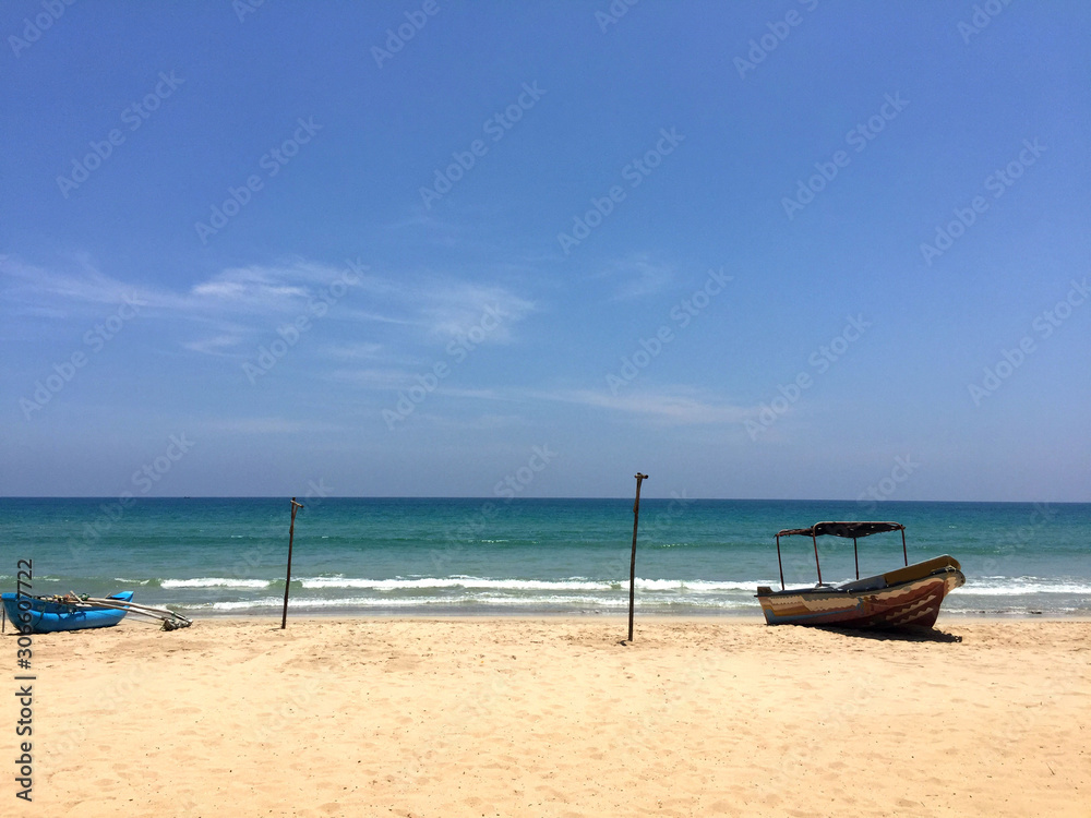  view from the beach to the ocean. Fishing boats on the shore and the complete absence of people. Sri Lanka, Trincomalee is unusually beautiful, green island