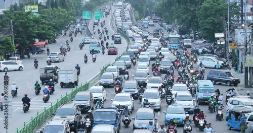 JAKARTA, Indonesia - November 27, 2019: Aerial view of undisciplined cars and motorcycles driver in traffic jam on highway. Shot in 4k resolution photo