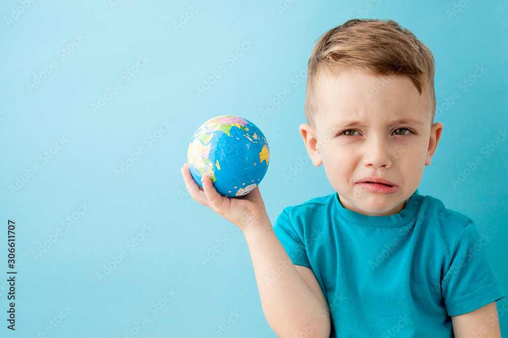 Little boy holding a globe on blue background Little boy holding a globe on blue background