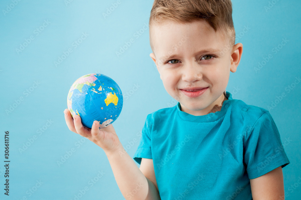 Little boy holding a globe on blue background Little boy holding a globe on blue background