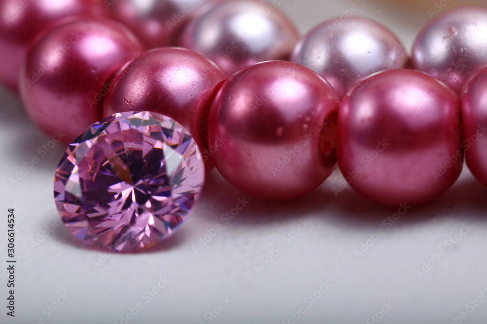 Close up shoot of an engagement ring on a pink pearl bracelet Close up shoot of an engagement ring on a pink pearl bracelet
