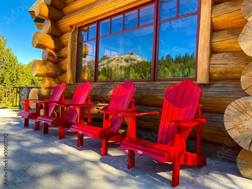 Red Adirondack Chairs on Log Cabin Deck