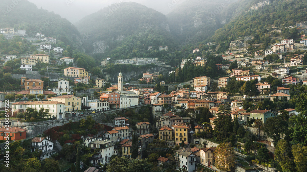Aerial panoramic drone view of Moltrasio town on Lago di Como lake, Italy. Foggy weather and mountains on background.