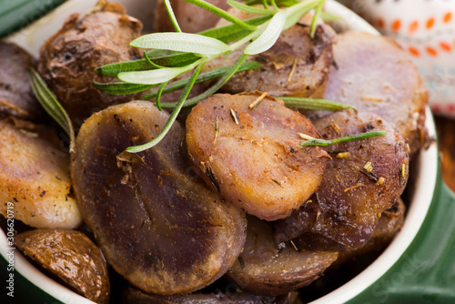 Fired violet potato slices with herbs, close view photo