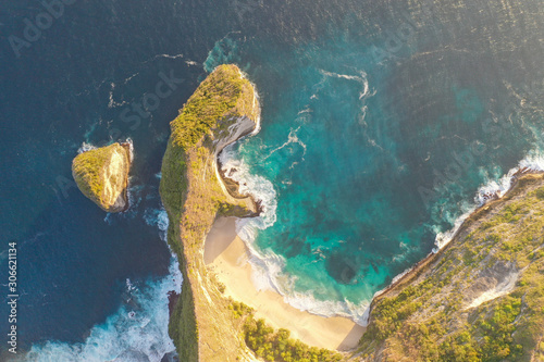 Aerial view of the Kelingking Beach aka Manta Bay with the amazing big wave and blue ocean located in Nusa Penida, Bali, Indonesia.