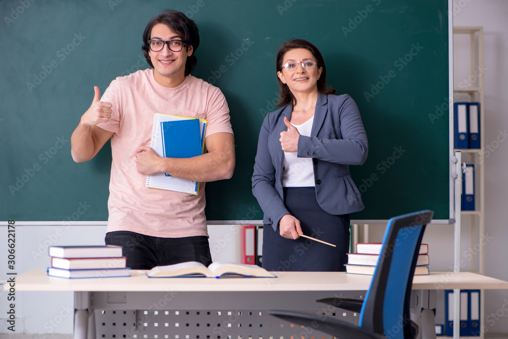 Old female teacher and male student in the classroom Old female teacher and male student in the classroom