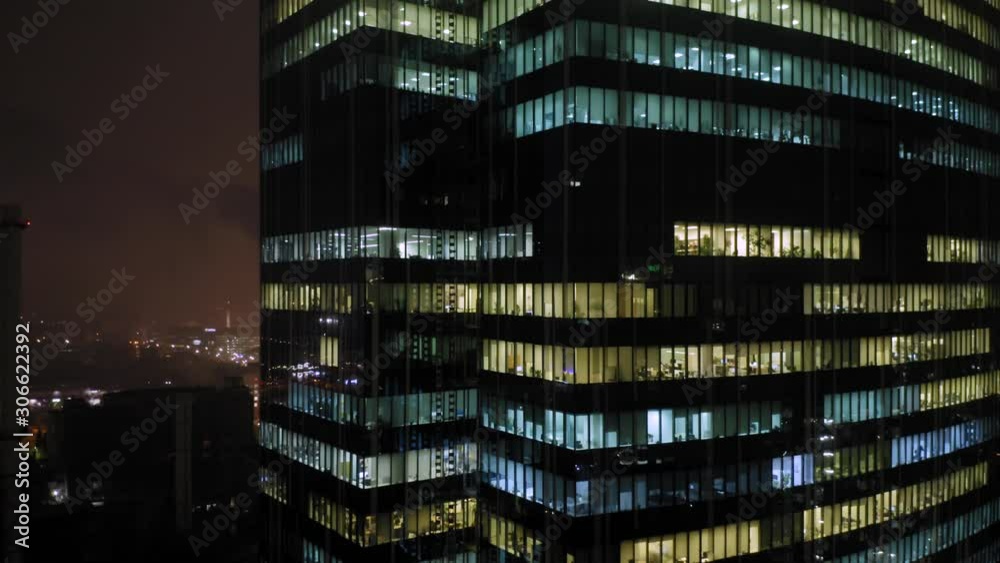 Aerial elevator shot of the skyscraper with a lot of office people inside, who works overtime at night Aerial elevator shot of the skyscraper with a lot of office people inside, who works overtime at night