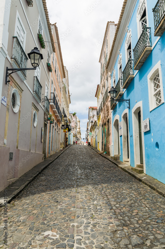 Bright sunny view of the historic tourist center of Pelourinho, Salvador da Bahia, Brazil featuring colorful colonial architecture on a broad cobblestone hill