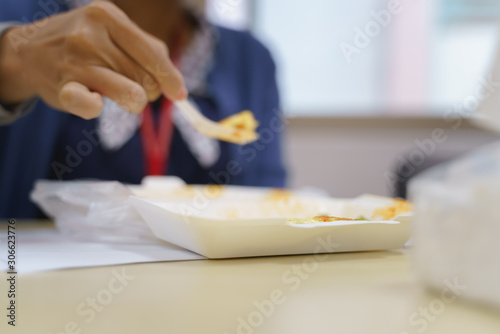 Woman in office uniform eating Thai food
