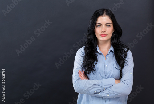 Young woman with crossed arms on a black background