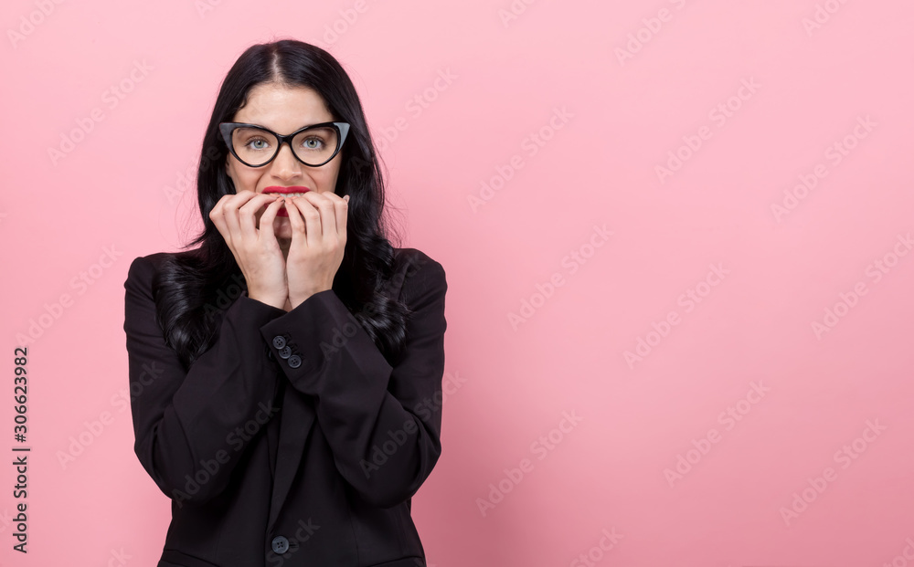 Scared young woman on a pink background
