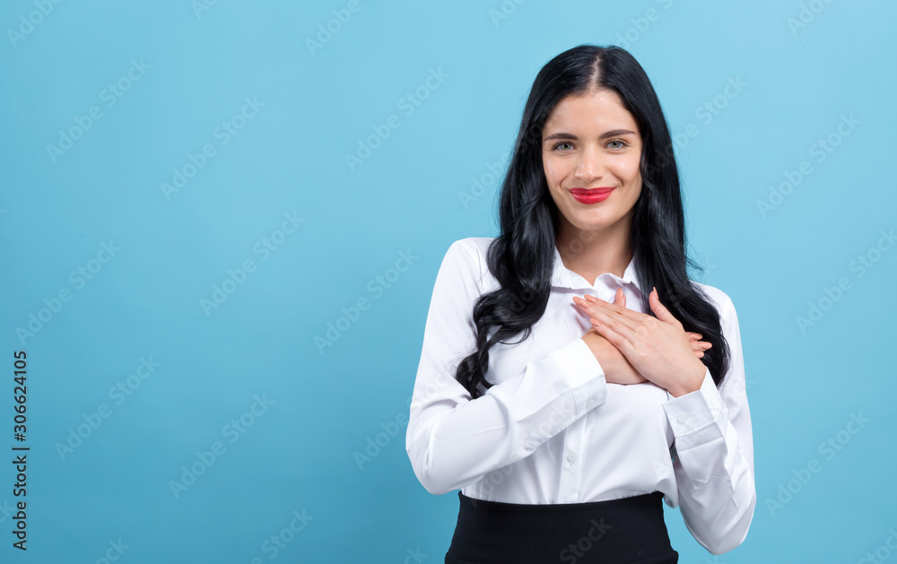 Woman with heartfelt expression on a blue background Woman with heartfelt expression on a blue background