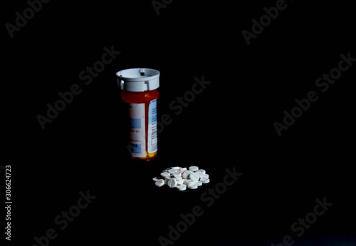Pills on table with prescription bottle left side