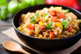 Fried rice with vegetables in a black bowl, Asian food	