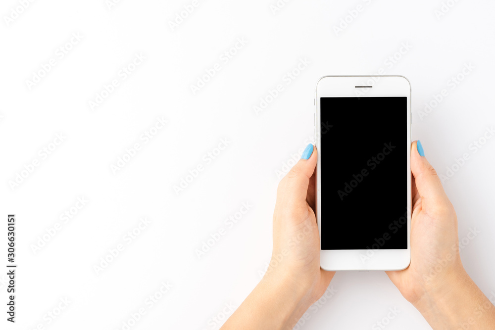 Overhead shot of female hands using smart phone with empty screen isolated on white background. Top view Overhead shot of female hands using smart phone with empty screen isolated on white background. Top view