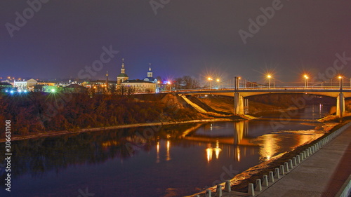 Russia, Smolensk famous landmark Uspensky Bridge across Dnieper river, embankment Park and Church, beautiful wide autumn evening view from City Observation deck on blue sky background