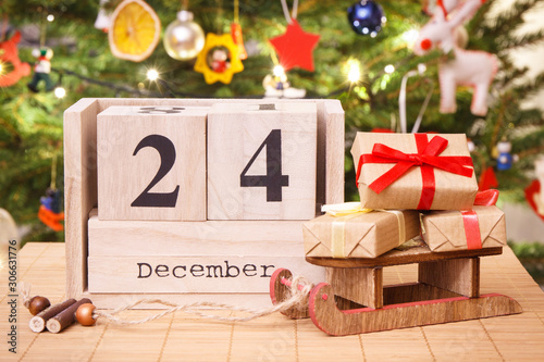 Date 24 December on calendar, wrapped gifts and christmas tree with decoration, Christmas eve time concept